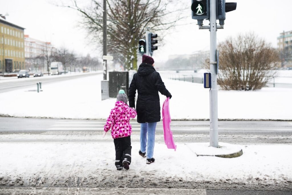Person walking carefully on icy sidewalk with anti-slip safety spray
