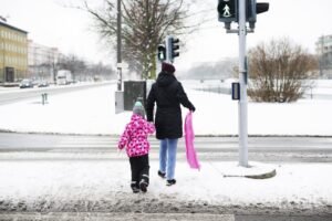Person walking carefully on icy sidewalk with anti-slip safety spray